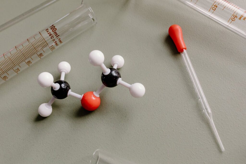 Close-up of laboratory equipment and molecular model on a flat surface.
